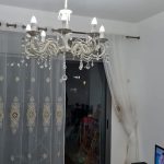 תמונה של סלון עם מנורת תקרה